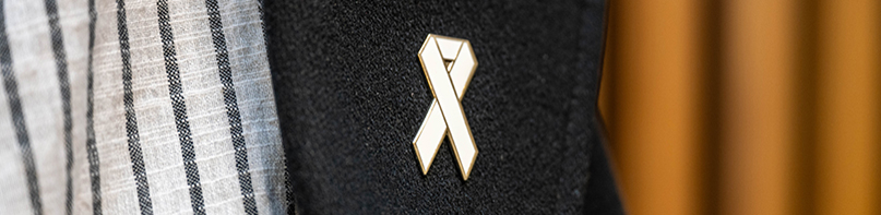 White Ribbon pinned on a dark grey coat lapel