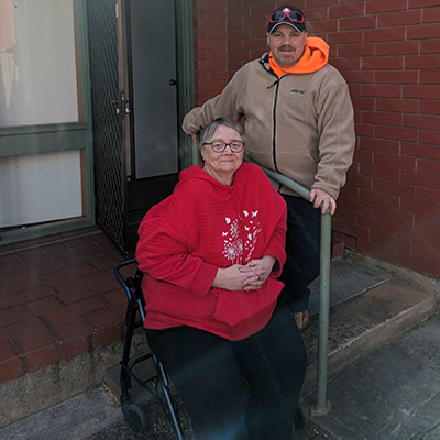 David and his mother in front of their home.