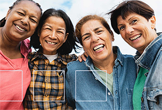 4 mature women hugging each other and laughing
