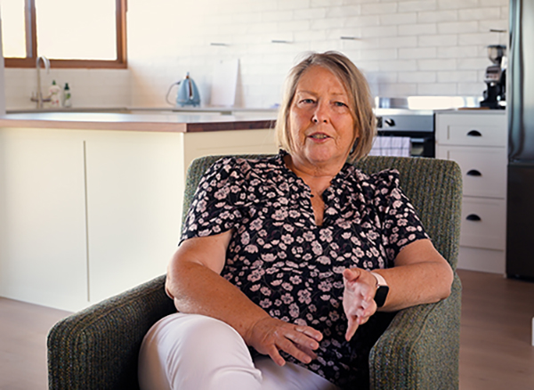 Sharon sitting in an armchair being interviewed