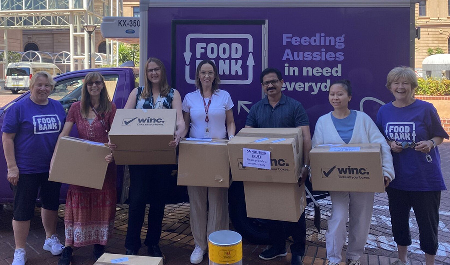 SA Housing Trust staff volunteers loading boxes of donated food into the Foodbank truck