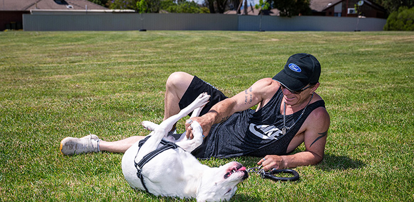 Kris and his dog Rock playing on the lawn in the park